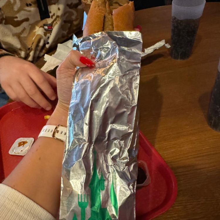 Vegan hotdog in a green foil wrapper.