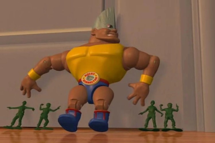 The muscular Rocky Gibraltar action figure toy standing on a wooden floor in front of a closed door, flanked by four small green plastic army men.